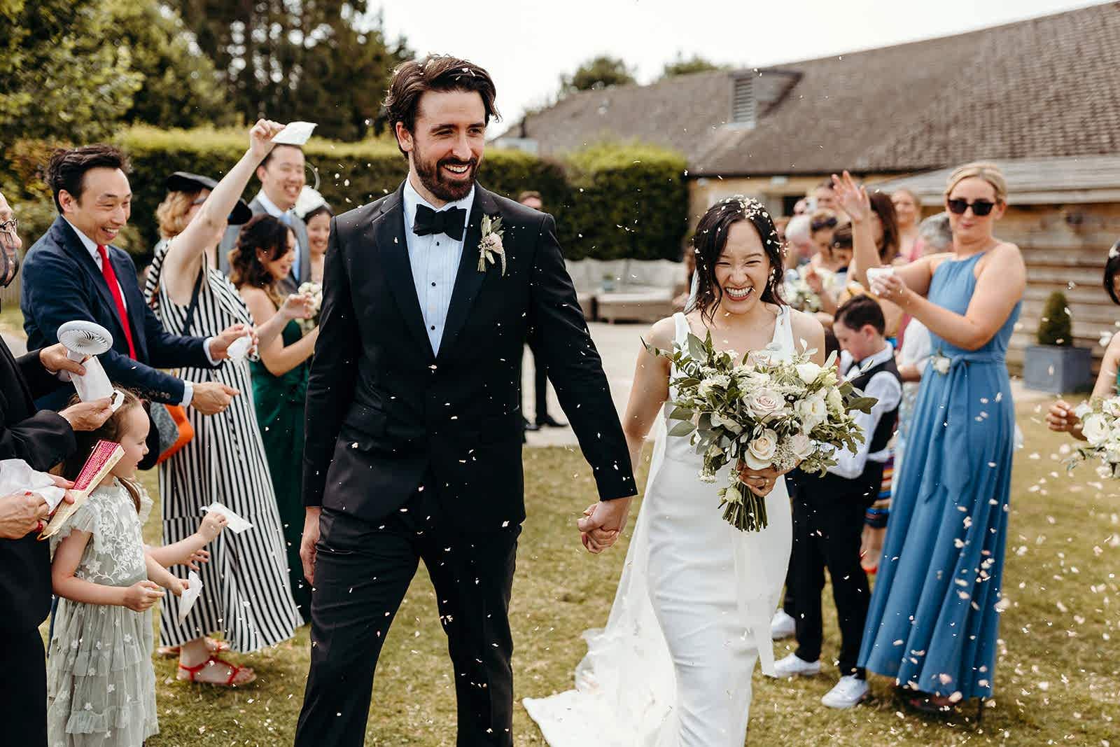 Kym & Rob - Lapstone Barn - Richard Skins Photography Bride and Groom just married being showered in confetti