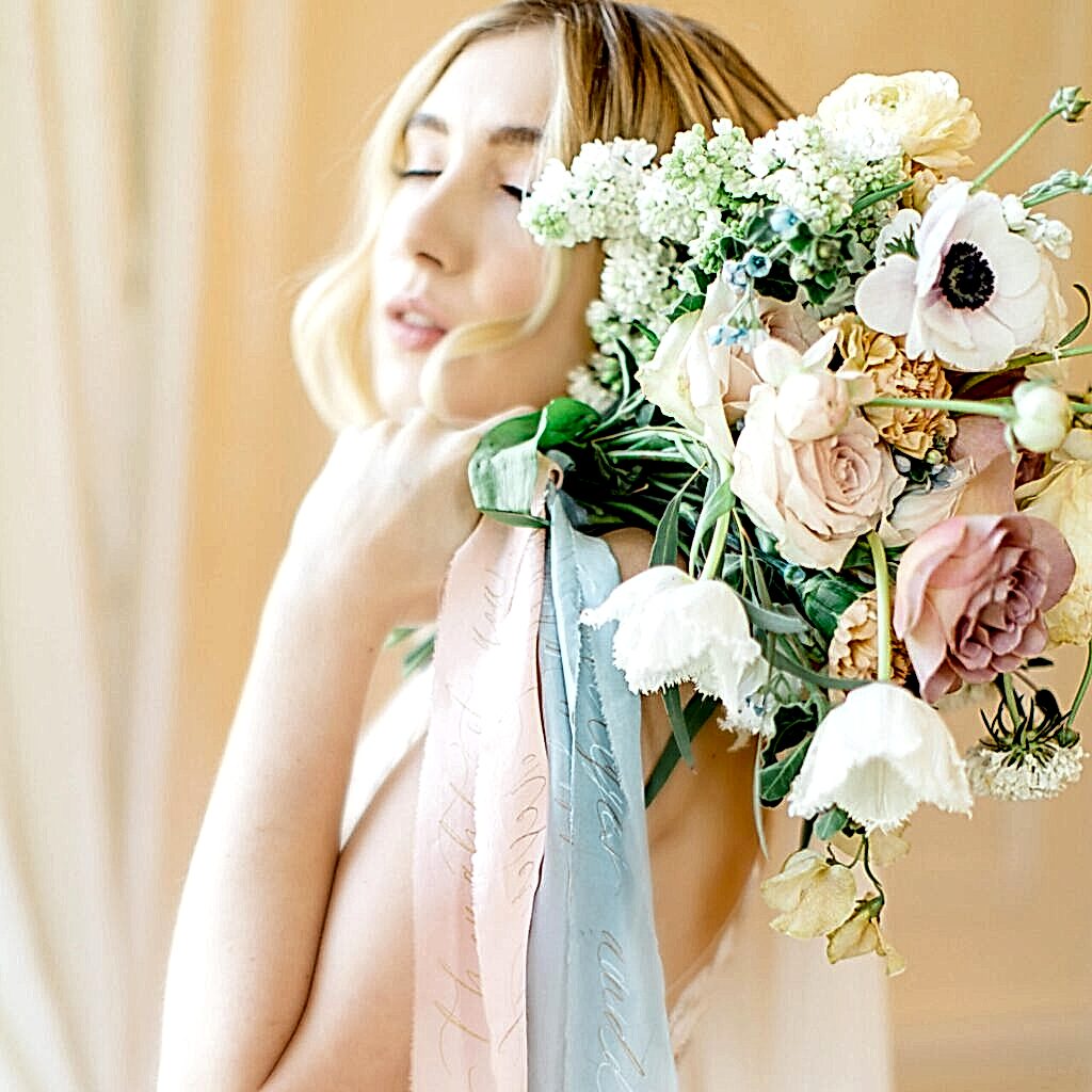 Beautiful bride with bouquet of flowers and trailing personalised ribbons