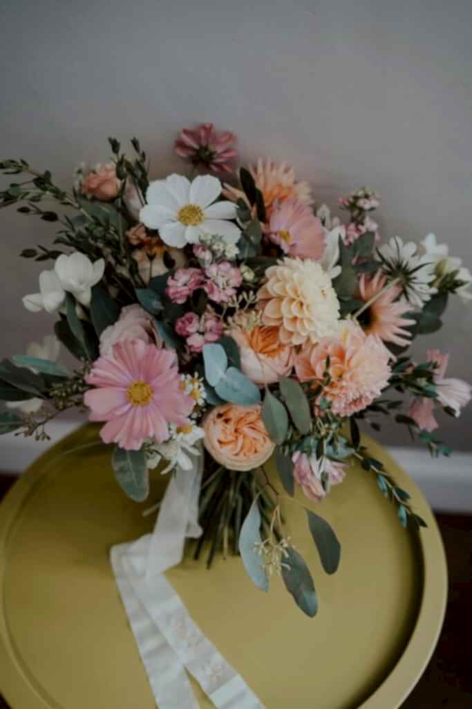 Bridal bouquet and personalised ribbons on a table, pre-wedding