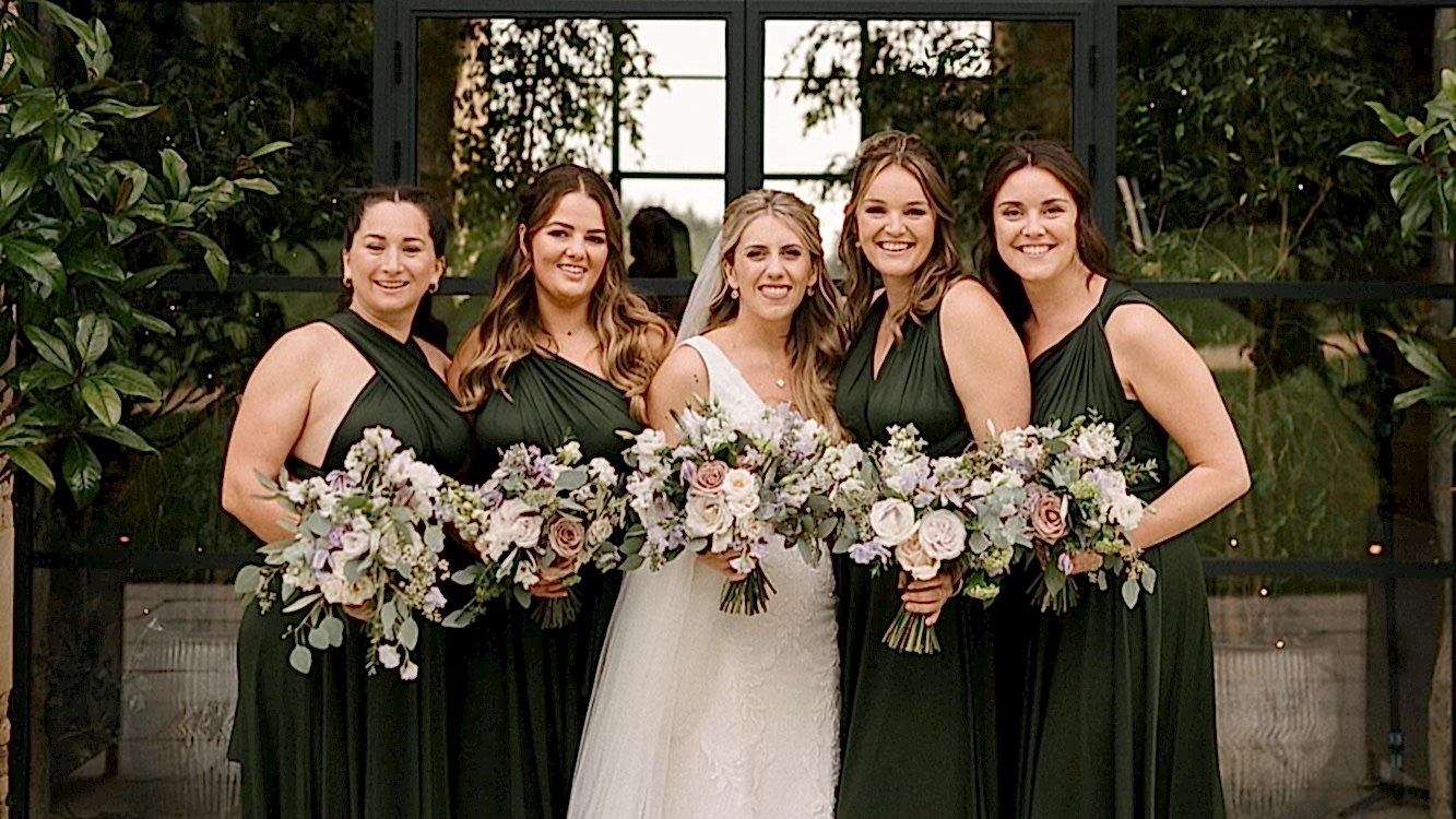Sophie and Oliver - The Shannons Photography - Old Gore Barn Bride and Bridesmaids in green dresses holding flowers at wedding venue in Cotswolds